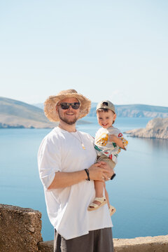 Father holding toddler at Croatia sea viewpoint