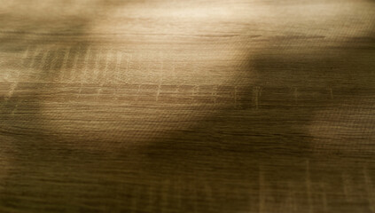 Fototapeta premium Abstract wooden surface, wood texture background. Wooden cutting board close up, blurred image. Sun reflections, warm colors