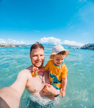 Father and toddler swimming in Adriatic sea