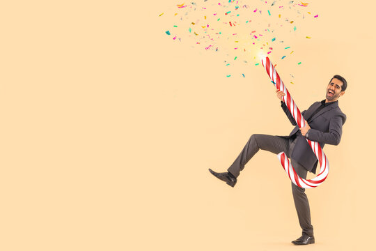 Happy businessman dancing with candy cane