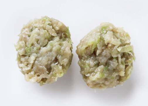 Two round, steamed siomay dumplings resting side by side on a clean white surface.