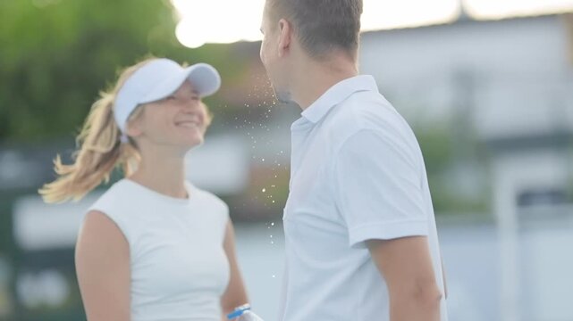 Tennis players refreshing spitting water after match