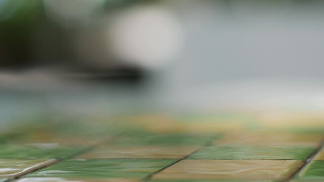 Wet Checkered Tile Floor with Shallow Focus and Blurred Bright Background