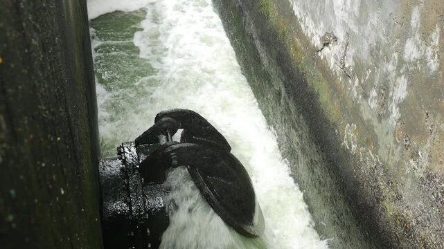 Iron Sluice Valve with Powerful Green Water Splash Close-Up