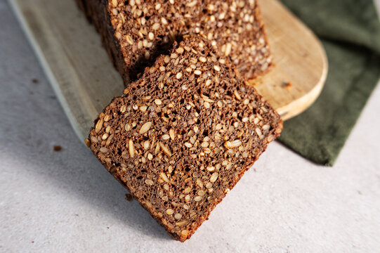 Close-up texture of sliced dark Danish rugbr&oslash;d or rye bread loaf.