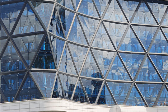 Contemporary architecture creating a vibrant abstract pattern from blue glass panels and steel structures, reflecting city environment