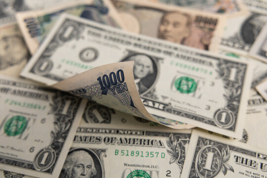 Japanese yen banknotes mixed with US dollar bills currency exchange background