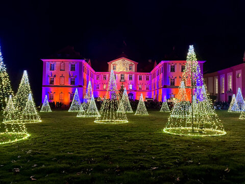 Mainau Island, Germany - December 13, 2025: Golden Light Trees Before the Illuminated Mainau Palace