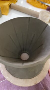 Handmade ceramic v60 coffee dripper on potter's wheel