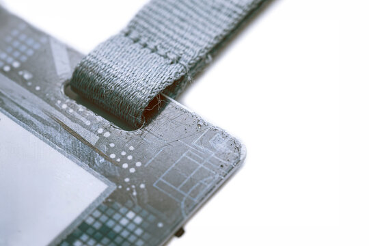 Close up of a worn ID badge with a grey lanyard