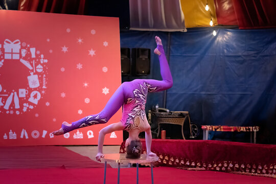 Young gymanst does a split handstand pose. Concept: Christmas holiday campaign ads, festive family entertainment, and youth talent promotions