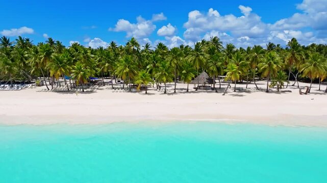 Amazing tropical resort beach with palm trees on white sand. Turquoise water and blue sky. Summer vacation at the all-inclusive resort and hotel in Punta Cana.