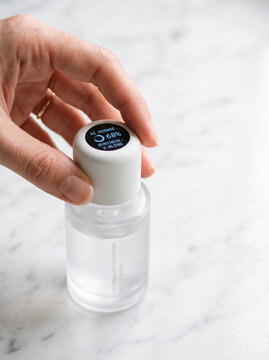 Hand Holding Smart Skincare Bottle with AI Digital Screen Display