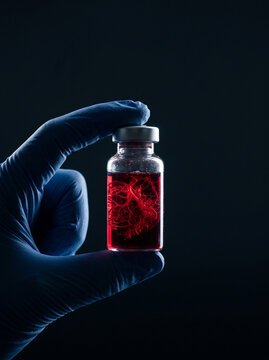 Hand Holding Glass Vial Containing Synthetic Red Vascular System Sample