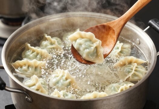 Cooking dumplings in boiling water with a wooden spoon
