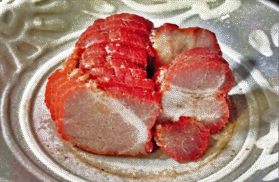 Sliced Chinese BBQ pork char siu with distinctive red outer layer served on a plate.