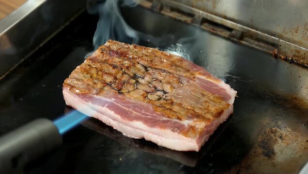 Extreme 4K macro food video capturing pork belly skin bubbling and blistering intensely under the flame of a kitchen blowtorch transforming into a golden ultra crunchy chicharr&oacute;n crackling texture