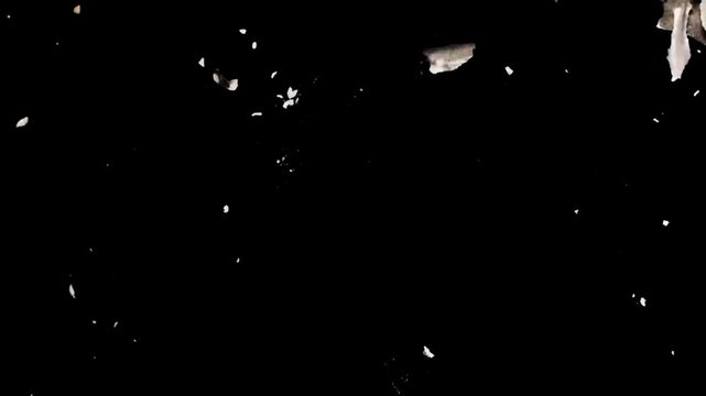 Abstract dark burnt paper pieces floating and scattering in the air