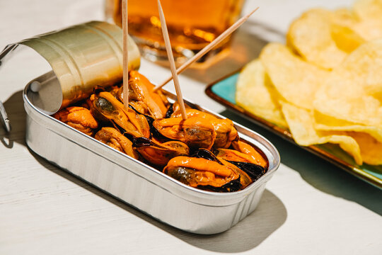 open tin of mussels with bar snacks