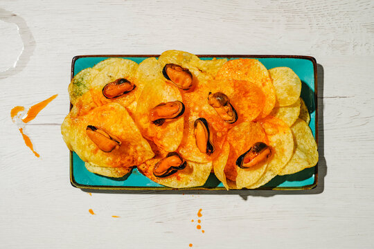 escabeche sauce splashed around mussels and chips