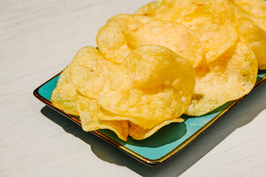 golden potato chips on a turquoise rectangular plate