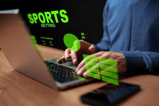 Person placing a sports bet online using a laptop with betting data displayed