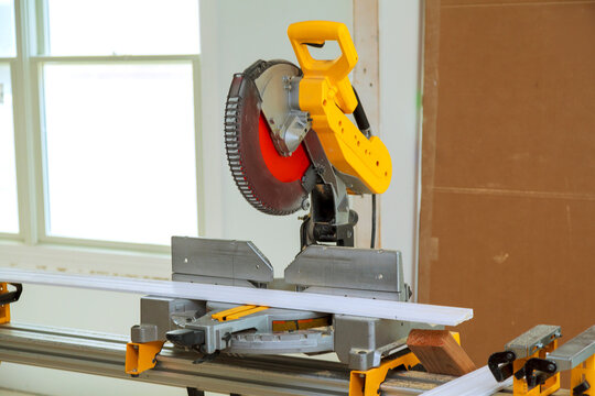 Saw is positioned on workstation in awork area tool materials are nearby as preparation for cutting begins.