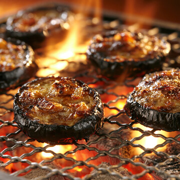 Slices of grilled eggplant cooking on charcoal barbecue grill with open fire