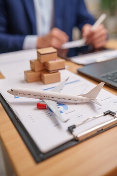 Air cargo logistics planning with aircraft model, shipment boxes and digital tablet, representing global freight operations.