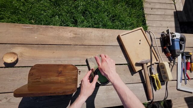 POV angle showing a creator securing a container lid on a rustic wooden table during a DIY carpentry session.