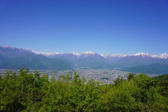 北アルプス　鷹狩山から望む残雪の北アルプスと新緑の大町市街