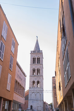 Bell tower of Saint Anastasia cathedral framed by Zadar alley, Croatia 