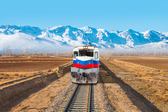 Red and blue diesel train (East express) in motion at the snow covered railway platform - The train connecting Ankara to Kars - Passenger train going through tunnel 