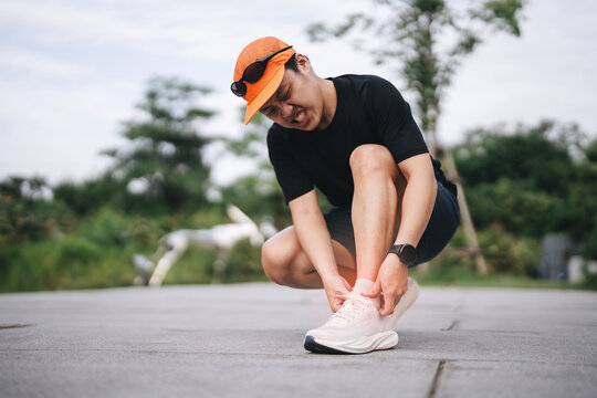 Adult asian sporty man emergency painful joint problem in training for marathon