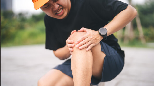 Adult asian sporty man knee pain joint problem in training for marathon