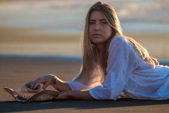 Woman relaxing on beach at golden hour sunset