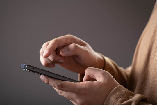 Close-up of a person using a smartphone with touchscreen interaction. Concept of mobile technology, digital communication, online services, app usage, connectivity, and modern lifestyle.