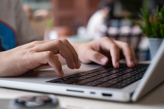 Hands typing on a laptop keyboard in a contemporary workspace, illustrating remote work, digital communication, business productivity, online learning, modern technology, and professional workflow.