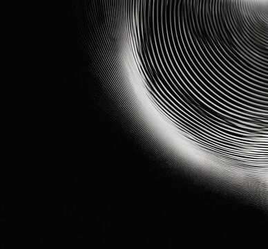 Concentric metallic lines radiate from a bright center against a dark background