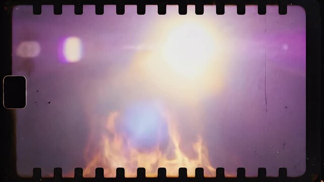 Intense flames blaze with vibrant colors and atmospheric light flares, framed by film grain