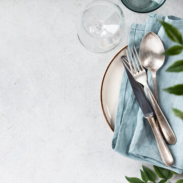 Elegant Table Setting with Vintage Cutlery and Greenery
