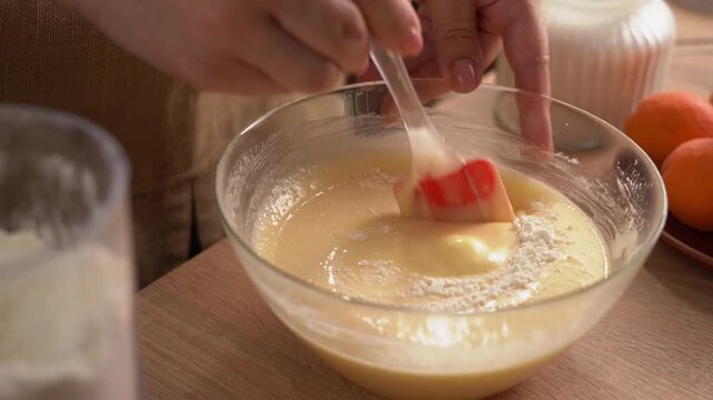 The process of preparing a liquid dough from eggs and flour, women's hands pour the ingredients into a bowl and then mix everything together