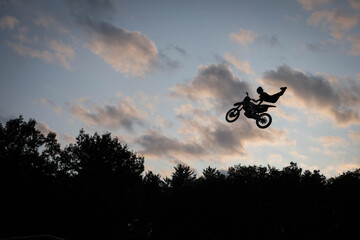 Fototapeta premium sunset silhouette of a motocross biker in air