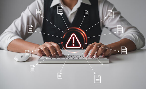 Professional typing on keyboard surrounded by document icons with central warning symbol.