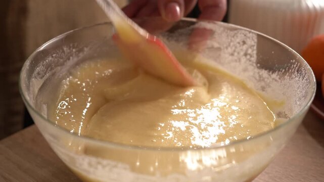 The process of preparing a liquid dough from eggs and flour, women's hands pour the ingredients into a bowl and then mix everything together