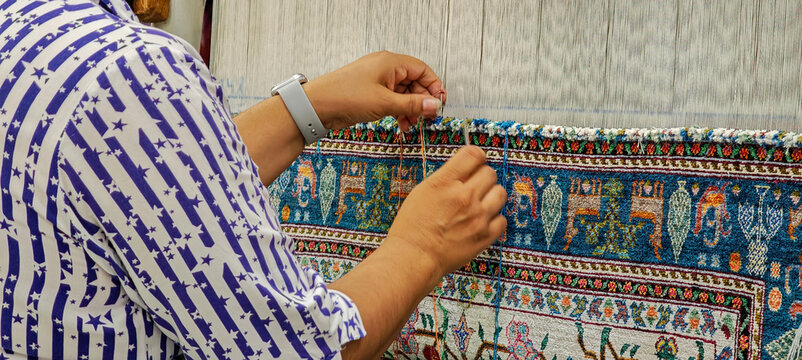 Women weaving a silk carpet on a factory of Bukhara on Uzbekistan