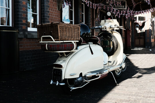 Vintage scooter parked beside brick building