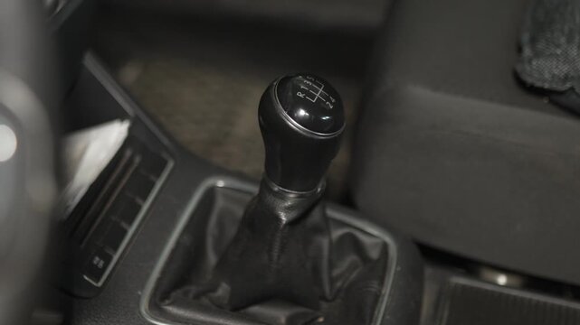 A manual transmission gear shift knob inside a car interior.