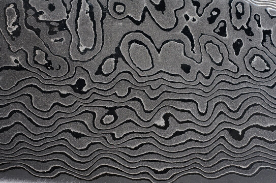 Surface of the Damascus steel blade with a unique wavy pattern