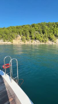 Luxury boutique yacht anchored in Croatia with water access stairs and water sports equipment. Vertical video showing paddleboards, floats, Adriatic Sea and a premium summer vacation lifestyle.